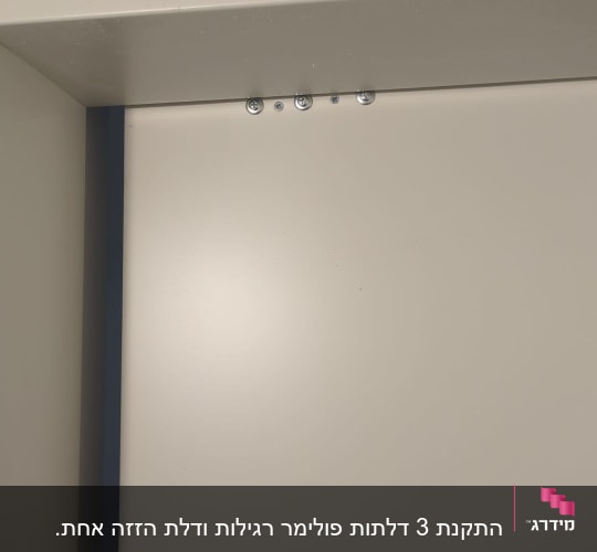 דלת לבנה עם ברגים בחלק העליון
